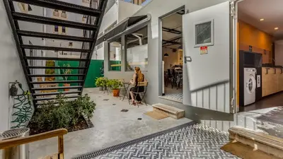 a woman sitting at a table in a building at Hostellicious in Faro