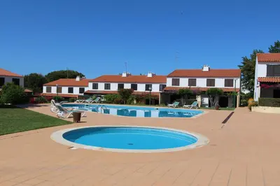 a large swimming pool in a yard with houses at Vilar do Jardim 59 - Clever Details in Vilamoura