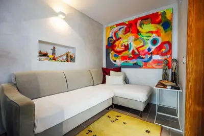 a living room with a couch and a painting at Casa do Sal in Albufeira