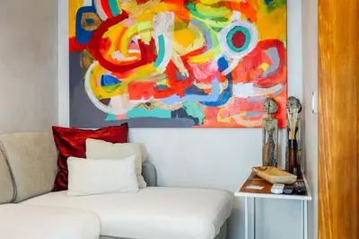 a living room with a white couch and a painting at Casa do Sal in Albufeira