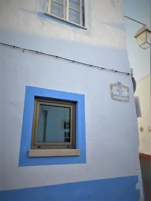 a blue and white building with a window at Casa do Sal in Albufeira