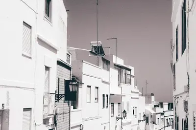 a black and white photo of an alley between buildings at Casa do Sal in Albufeira