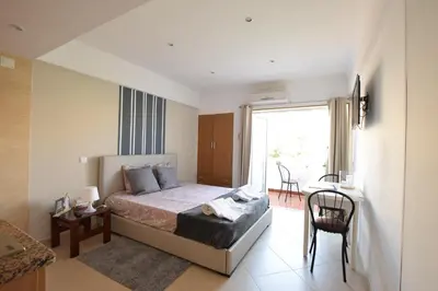 a bedroom with a bed and a table and a window at Peneco II in Albufeira