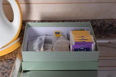a box of books on a table next to a cup at Peneco II in Albufeira