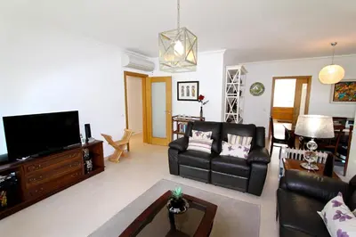 a living room with black leather furniture and a flat screen tv at Villa Violeta 51 - Clever Details in Vilamoura