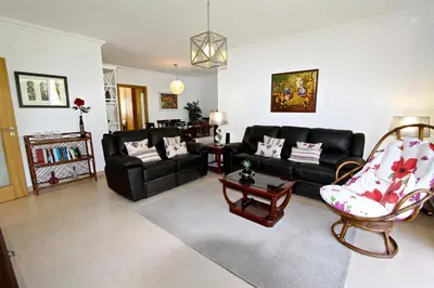 a living room with a black couch and a chair at Villa Violeta 51 - Clever Details in Vilamoura