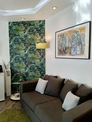 a living room with a couch and a painting on the wall at Little Wonder Apartment in Albufeira