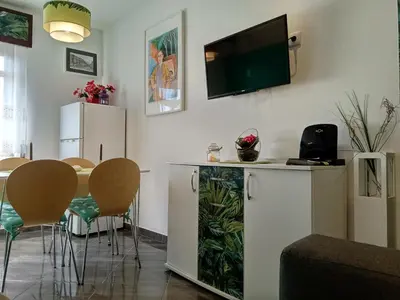a living room with a table and a television on the wall at Little Wonder Apartment in Albufeira