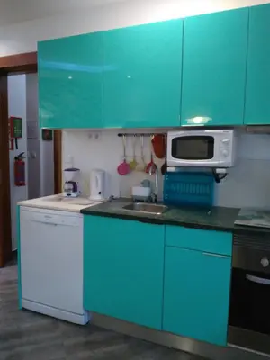 a blue kitchen with a sink and a microwave at Little Wonder Apartment in Albufeira