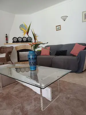 a living room with a couch and a glass table at The Pinewood Villa in Vilamoura