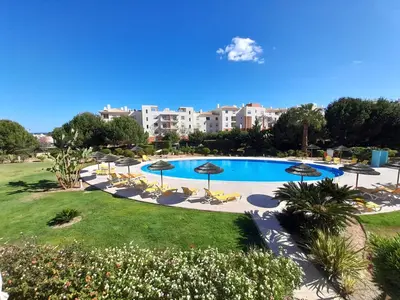 a view of a pool with umbrellas and chairs at Blue House Corcovada in Albufeira