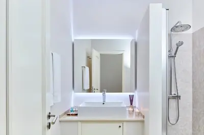 a white bathroom with a sink and a shower at Ancão Gardens in Quinta do Lago