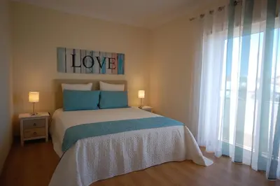 a bedroom with a bed with the word love on it at Apartamento Edificio Ibérico - Albufeira downtown in Albufeira