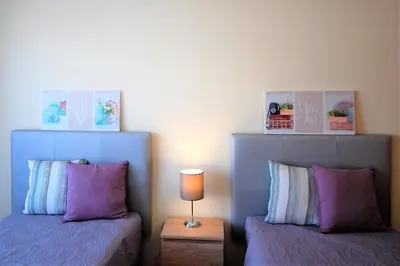 a bedroom with two beds and a table with a lamp at Apartamento Edificio Ibérico - Albufeira downtown in Albufeira
