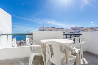 a white table and chairs on a balcony with a view at Apartamento Correia in Albufeira