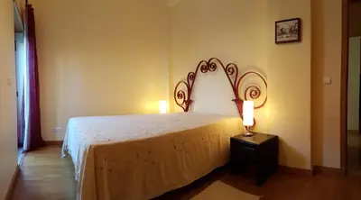 a bedroom with a bed and a lamp on a table at Albufeira Marina Villa 27 in Albufeira