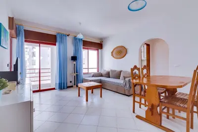 a living room with a table and a couch at Apartamento T1 praia in Quarteira