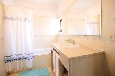 a bathroom with a sink and a shower curtain at Dinita Apartamento nº4 in Albufeira