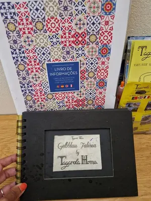 a person is holding a notebook with a patterned box at GelbBlau Falésia in Albufeira