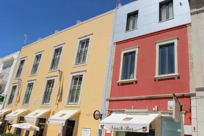 a row of colorful buildings on a street at Dom Fernando II in Loulé