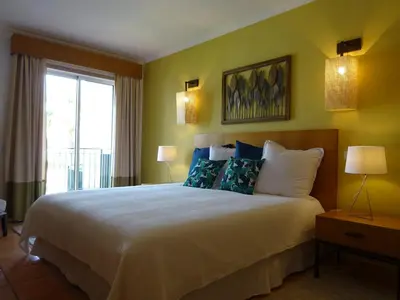 a bedroom with a bed with two lamps and a window at T3 Vila Sol Village in Quarteira