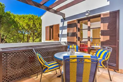 a patio with a table and chairs on a balcony at Algarve Luxury Experience - Situated within the Pinecliffs Resort in Albufeira