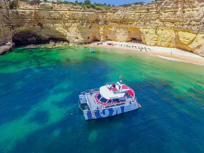 a boat in the water next to a beach at Apartment Old Town Center Albufeira Walk to Beach in Albufeira
