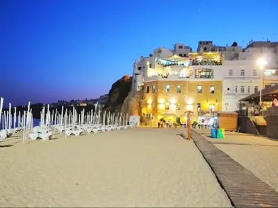 a building on a beach in front of the water at Apartment Old Town Center Albufeira Walk to Beach in Albufeira