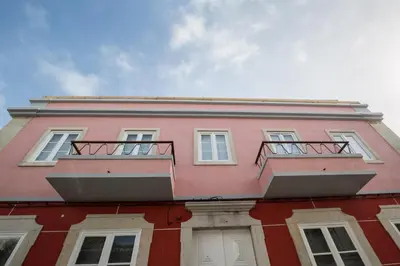 a pink building with two balconies on top of it at 1977 in Faro