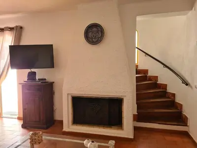 a living room with a fireplace and a tv at Aldeia do Golf - Vila I4 in Vilamoura