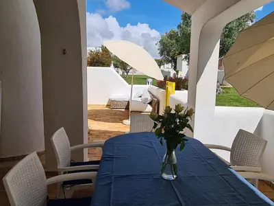 a vase of flowers sitting on a table on a patio at Aldeia do Golf - Vila I4 in Vilamoura