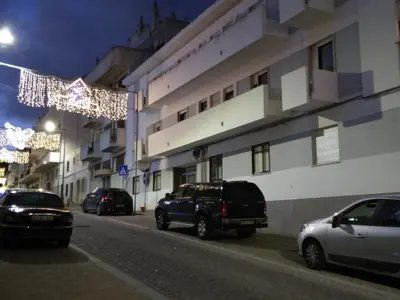 a street with cars parked next to a building with christmas lights at Wonder Villa in Albufeira