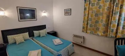 a small bedroom with a bed with a blue bedspread at Bellavista Tenis Clube A4 T1 - Albufeira INN in Albufeira