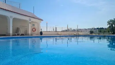 a large blue swimming pool next to a building at Albufeira Ocean view (62) in Albufeira