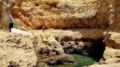 a person standing on a cliff next to a body of water at Albufeira Ocean view (62) in Albufeira