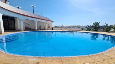 a large blue swimming pool in front of a building at Albufeira Sea view (51) in Albufeira