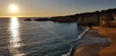 a beach with the sun rising over the water at Albufeira sea view (52) in Albufeira