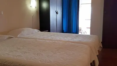 a bedroom with a bed and a window with blue curtains at Albufeira sea view (52) in Albufeira