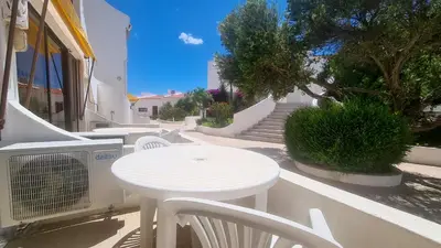 a white table and chairs on a sidewalk with stairs at Albufeira, Cerro Branco (41) in Albufeira