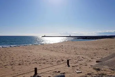 a sandy beach with a pier in the ocean at Albufeira, Cerro Branco (41) in Albufeira