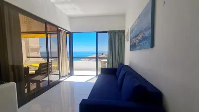 a living room with a blue couch and a view of the ocean at Albufeira, Sea and old town view (32) in Albufeira