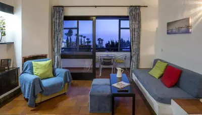 a living room with a couch and two chairs at Apartamentos Azul Mar in Albufeira