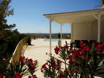 a patio with a pool and a pavilion with red flowers at Quinta Sabaudia in Gateiras