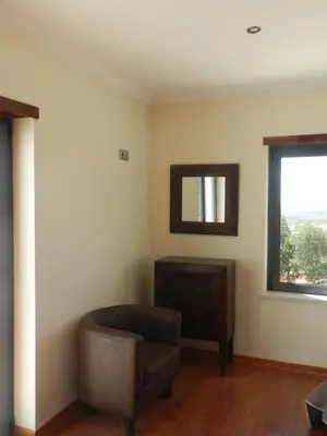 a living room with a chair and a mirror at Quinta Sabaudia in Gateiras