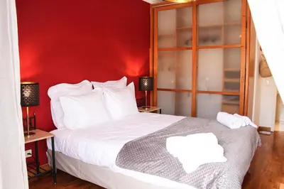 a bedroom with a red wall and a bed at Alameda Garden in Faro