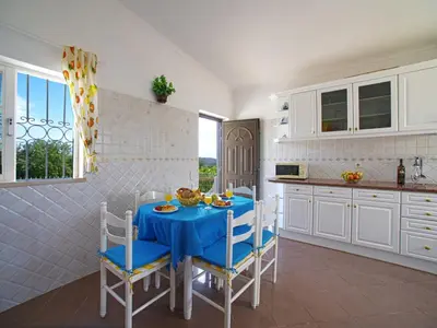 a kitchen with a blue table and chairs in a kitchen at Holiday Home Da Bela Vista by Interhome in Paderne