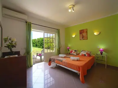 a bedroom with green walls and a bed with an orange blanket at Holiday Home Da Bela Vista by Interhome in Paderne