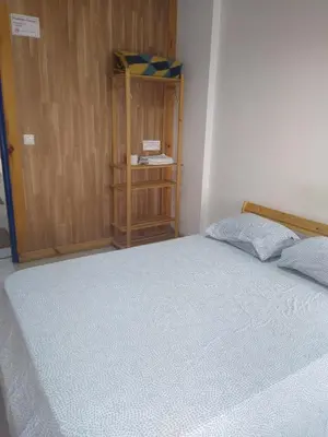 a bedroom with a bed and a wooden cabinet at Melaya Budget Hostel in Faro