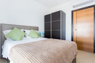 a bedroom with a large bed with green pillows at Ouranascente in Albufeira