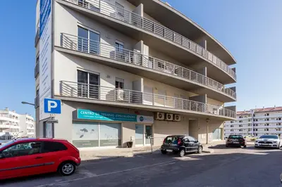 a apartment building with cars parked in front of it at Ouranascente in Albufeira
